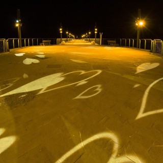 Il molo di Alassio illuminato di giallo in occasione dell'8 marzo