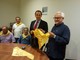Nella foto il presidente dei “Fieui di caruggi” mentre consegna il foulard firmato da Roberto Vecchioni all’assessore regionale al Turismo Berlangieri