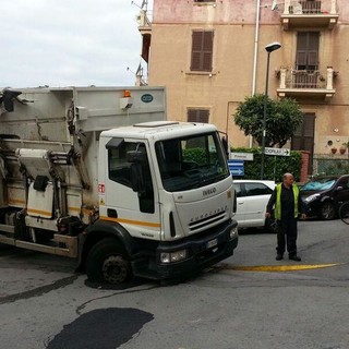 Il camion dei rifiuti bloccato in via Istria con la ruota nella buca (copy savonanews.it)