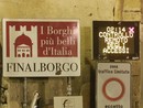 Continua la querelle degli adesivi a Finalborgo: ripulito il cartellone di Porta Reale