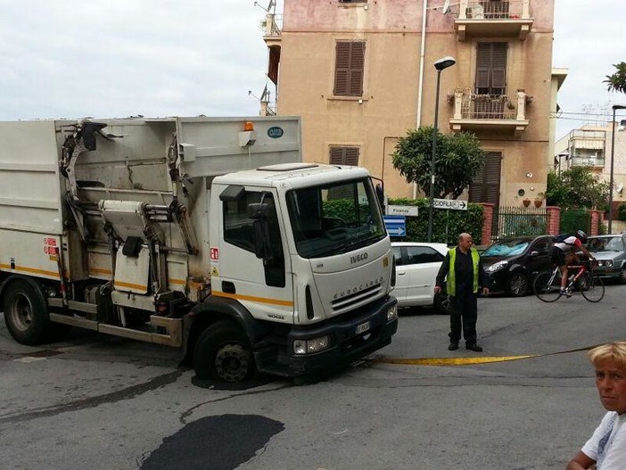 Il camion dei rifiuti bloccato in via Istria con la ruota nella buca (copy savonanews.it)