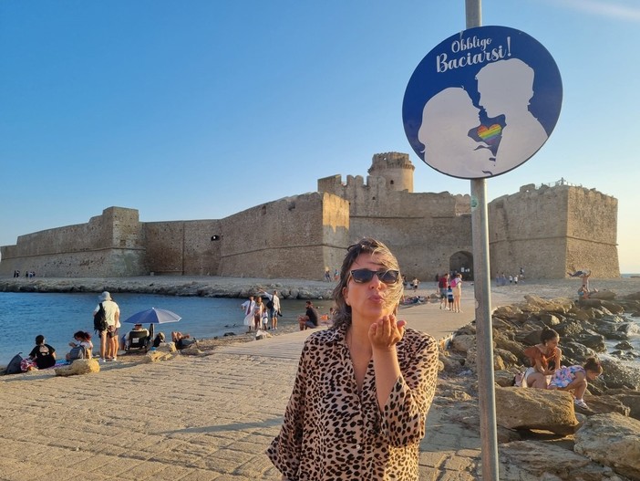 In foto il cartello “Obbligatorio baciarsi” a Le Castella (Crotone)